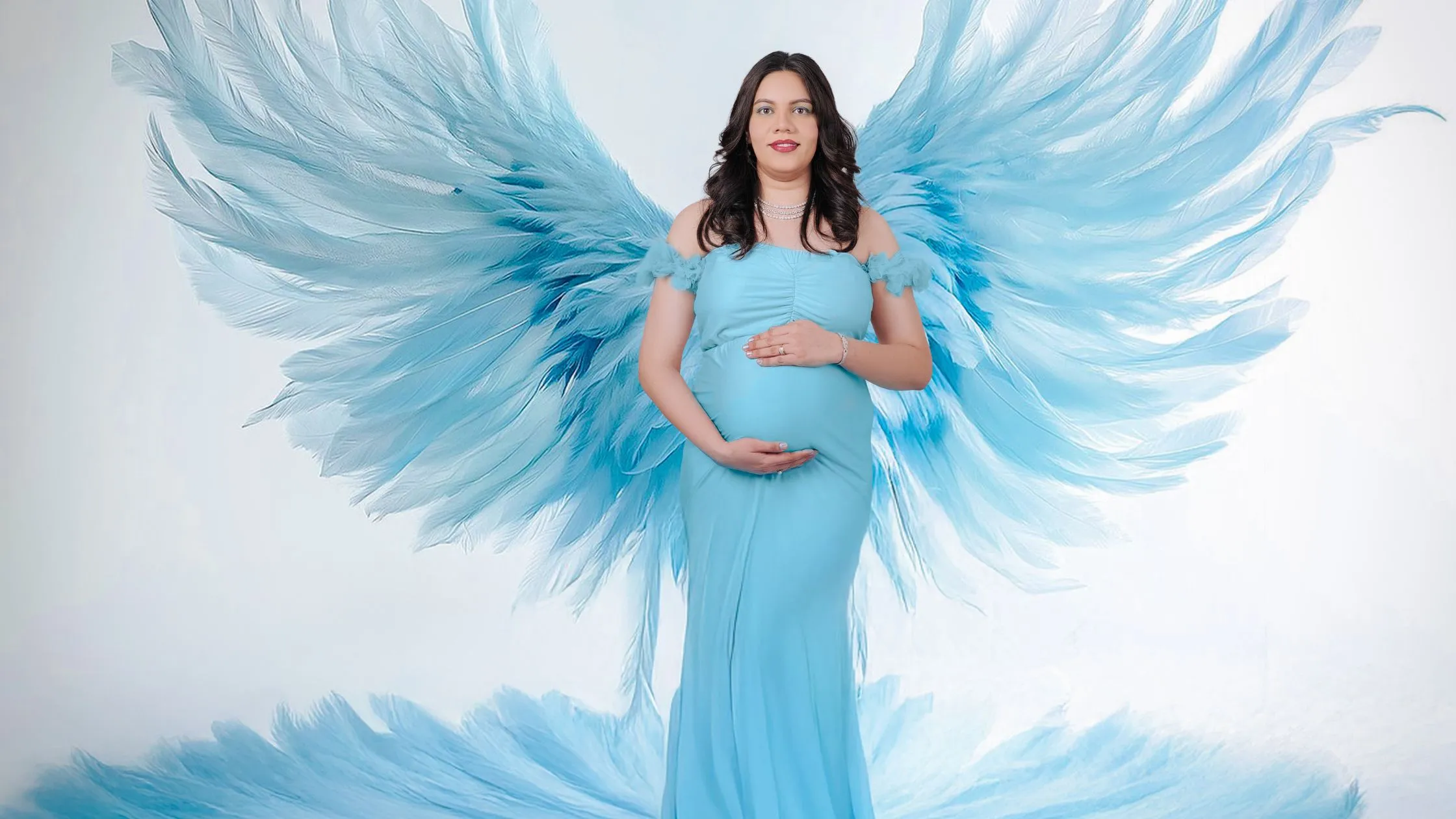 Creative maternity photoshoot with blue angel wings and elegant pregnancy gown by Indo Frames.
