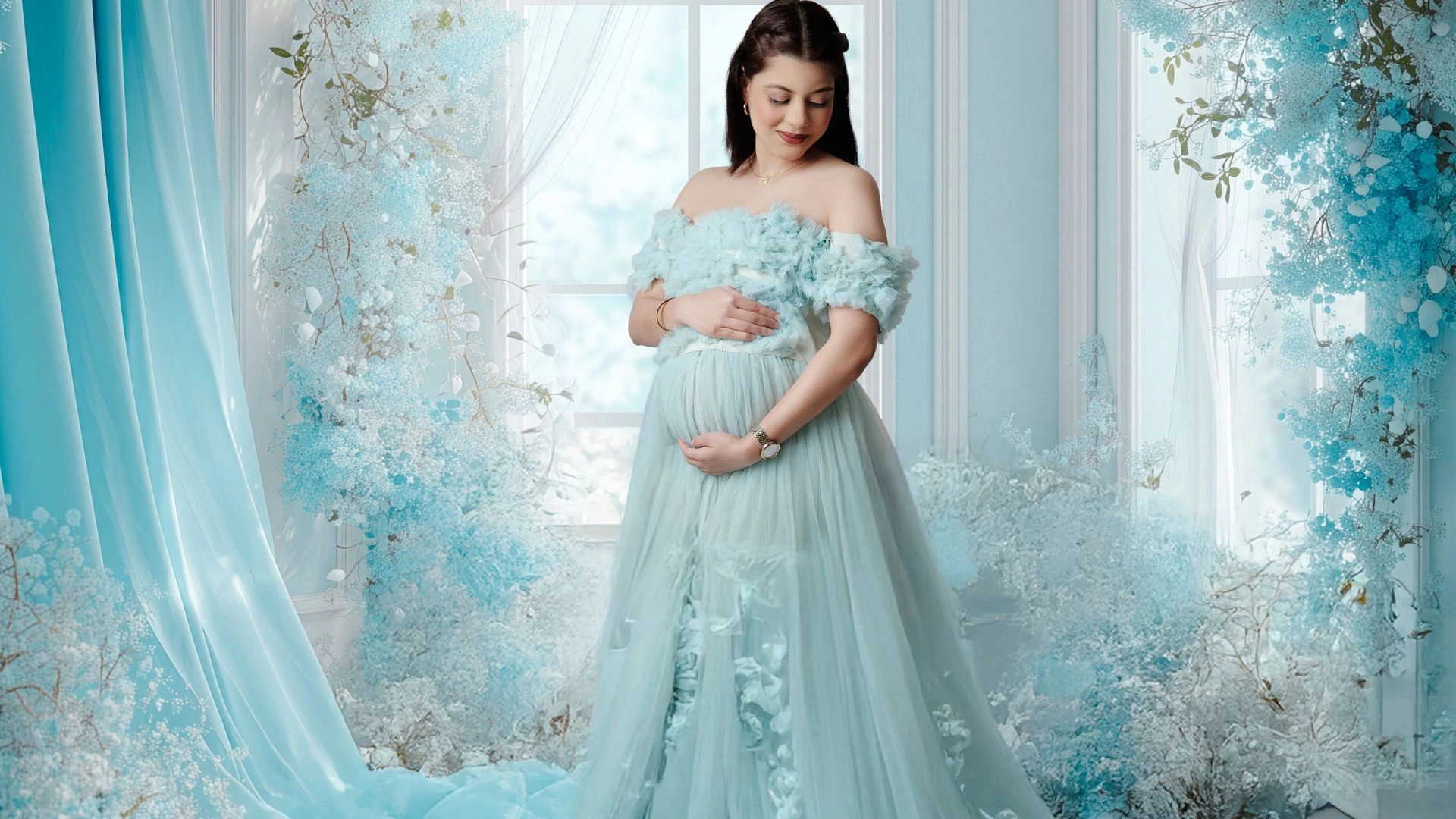 Beautiful maternity images of pregnant woman in blue floral gown holding baby bump by Indo Frames
