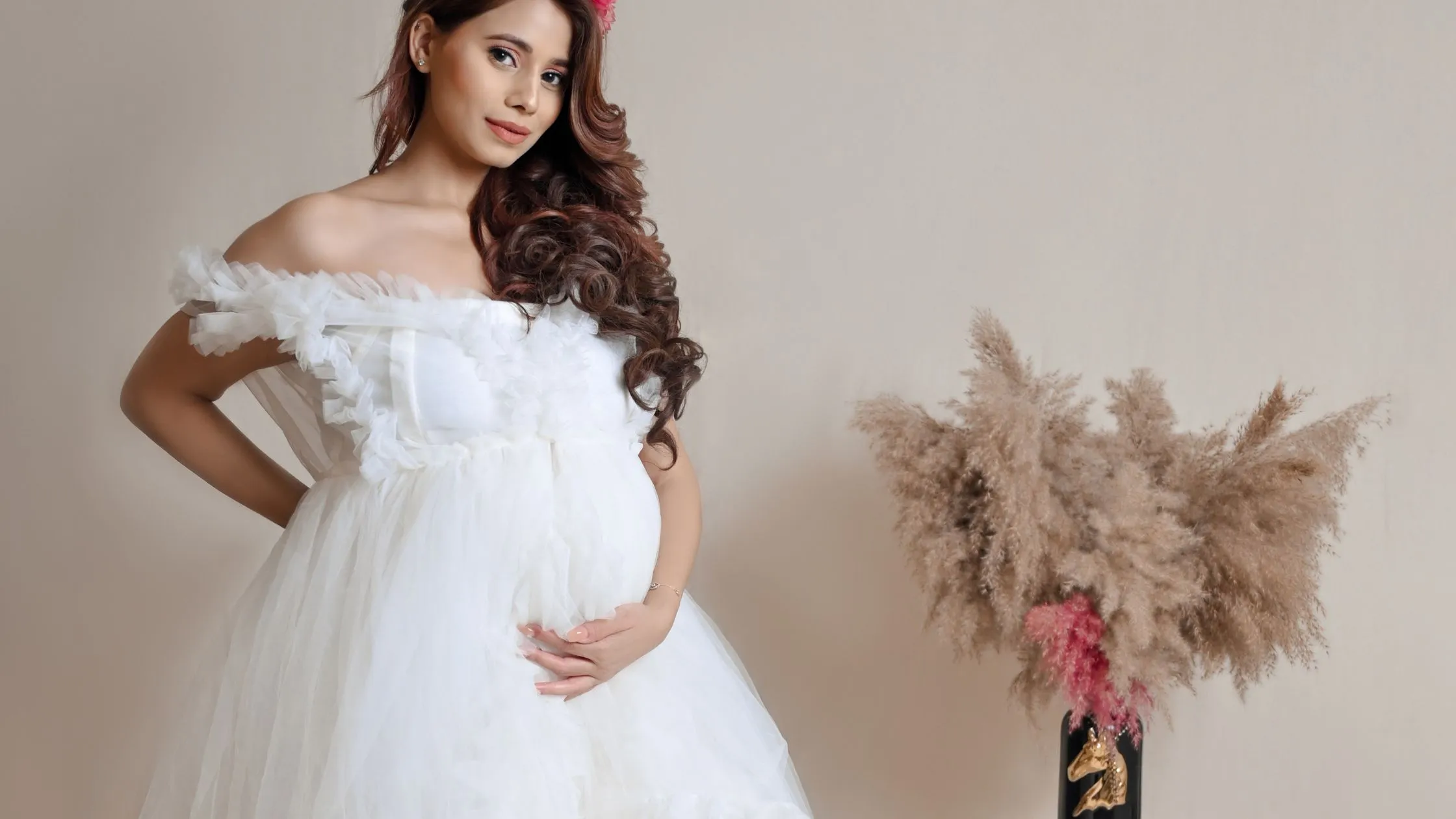 Pregnant lady posing in white gown for unique maternity photography by indo frames